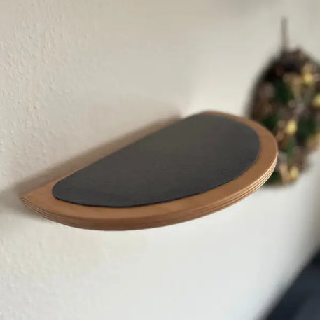 Halbkreisförmiges Holzregal mit schwarzer Oberfläche.