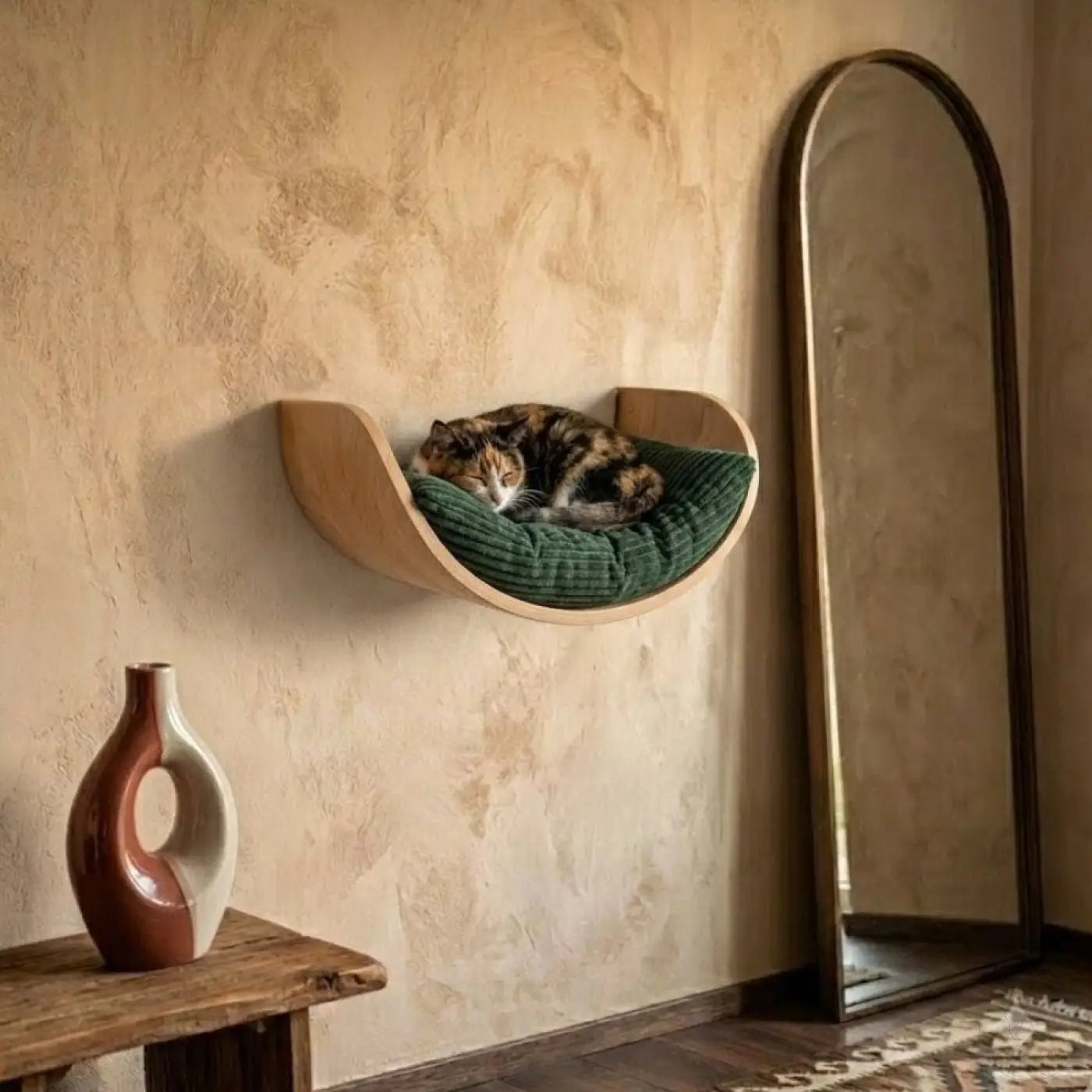 Eine elegante phinias fensterliege aus gebogenem holz mit grünem mondförmigem kissen und schlummernder schildpattkatze