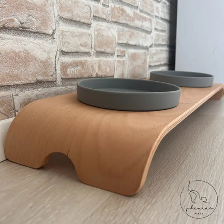 Erhöhte Futterstation für Haustiere mit zwei grauen Schalen.