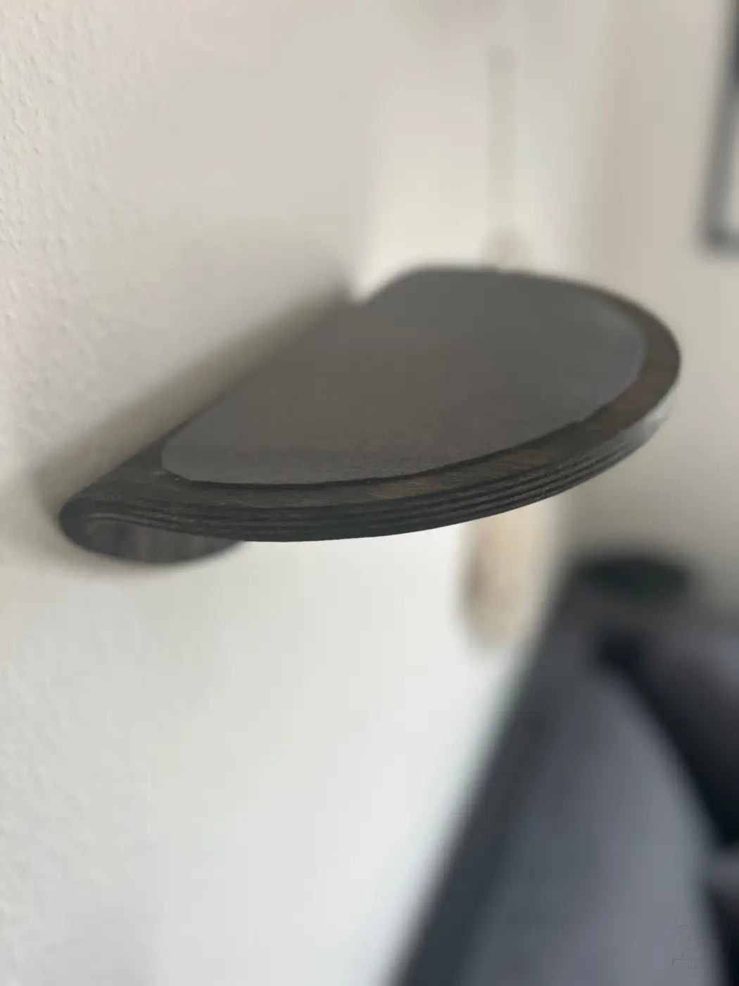 Dunkles, halbkreisförmiges Wandregal.