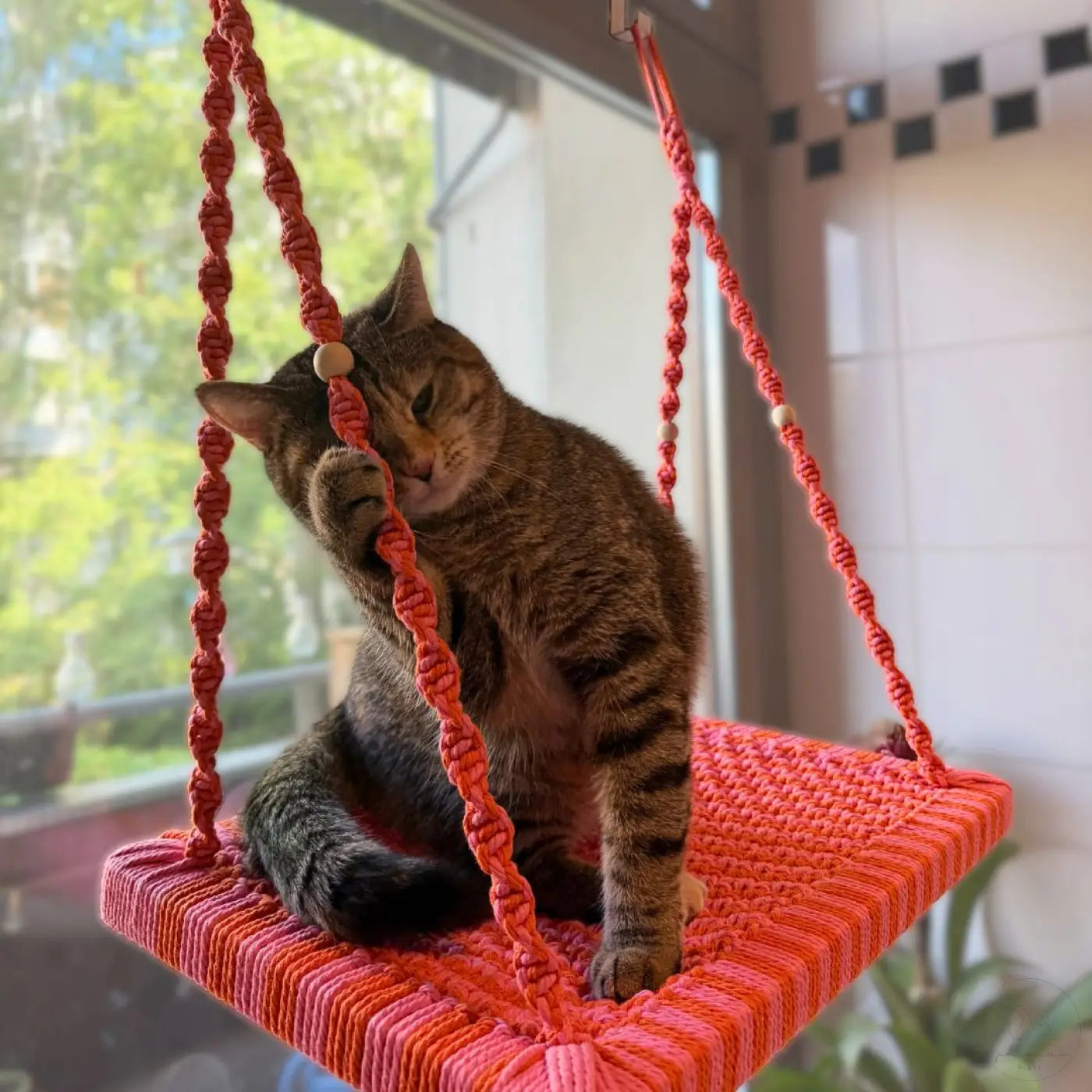 Cozy orange macrame katzenliege fensterplatz with woven texture and wooden beads from phinias sommeredition